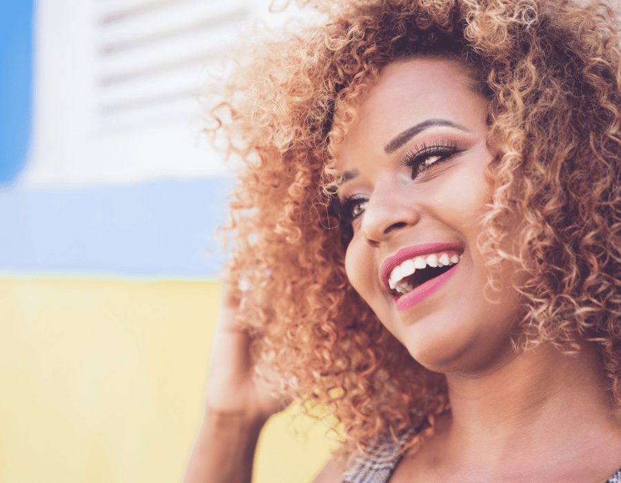 a woman with curly hair smiling