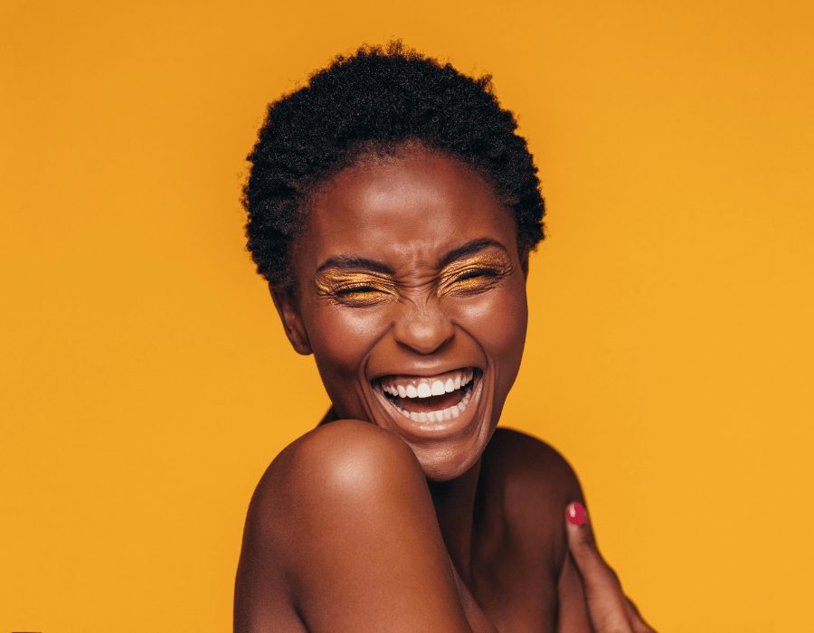 a woman laughing with her eyes closed