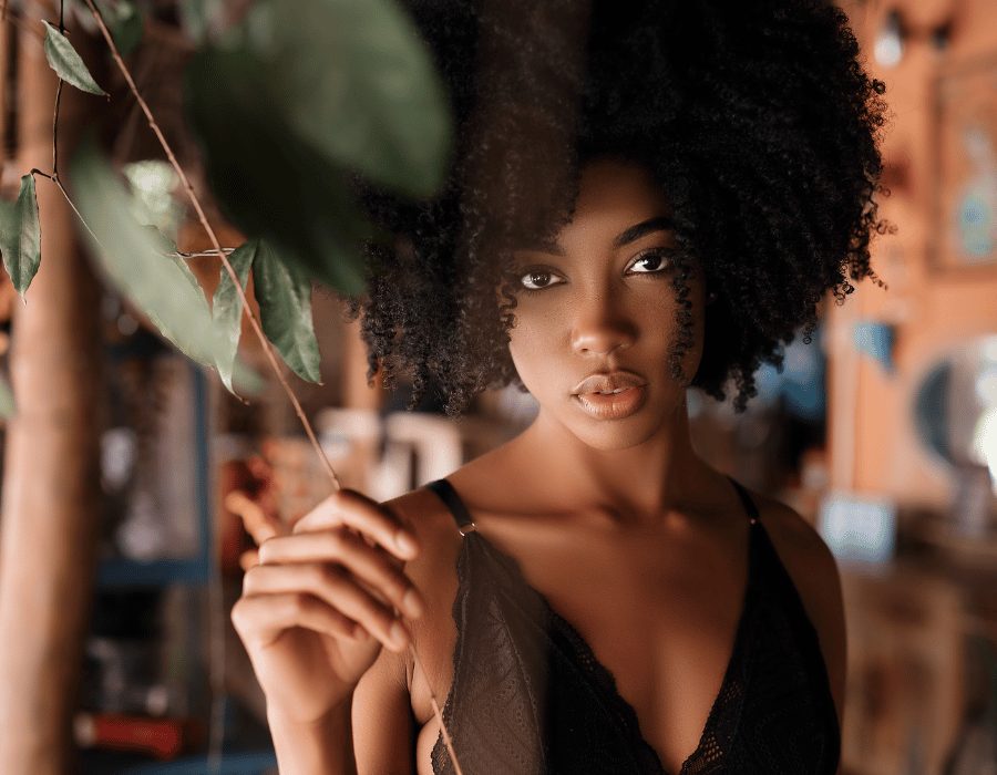 a woman with curly hair holding a plant