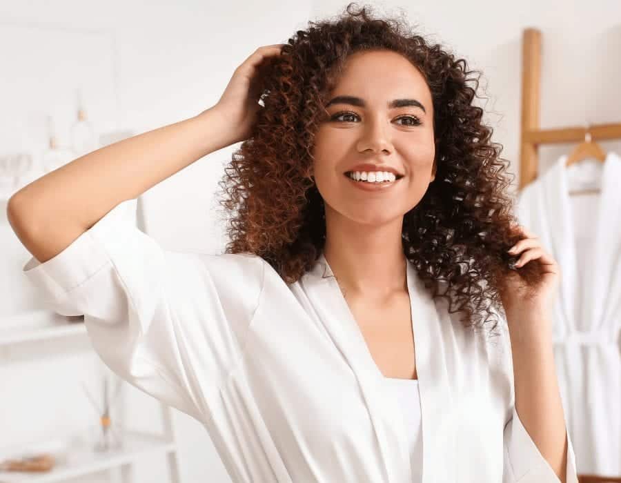 a woman with curly hair and white shirt